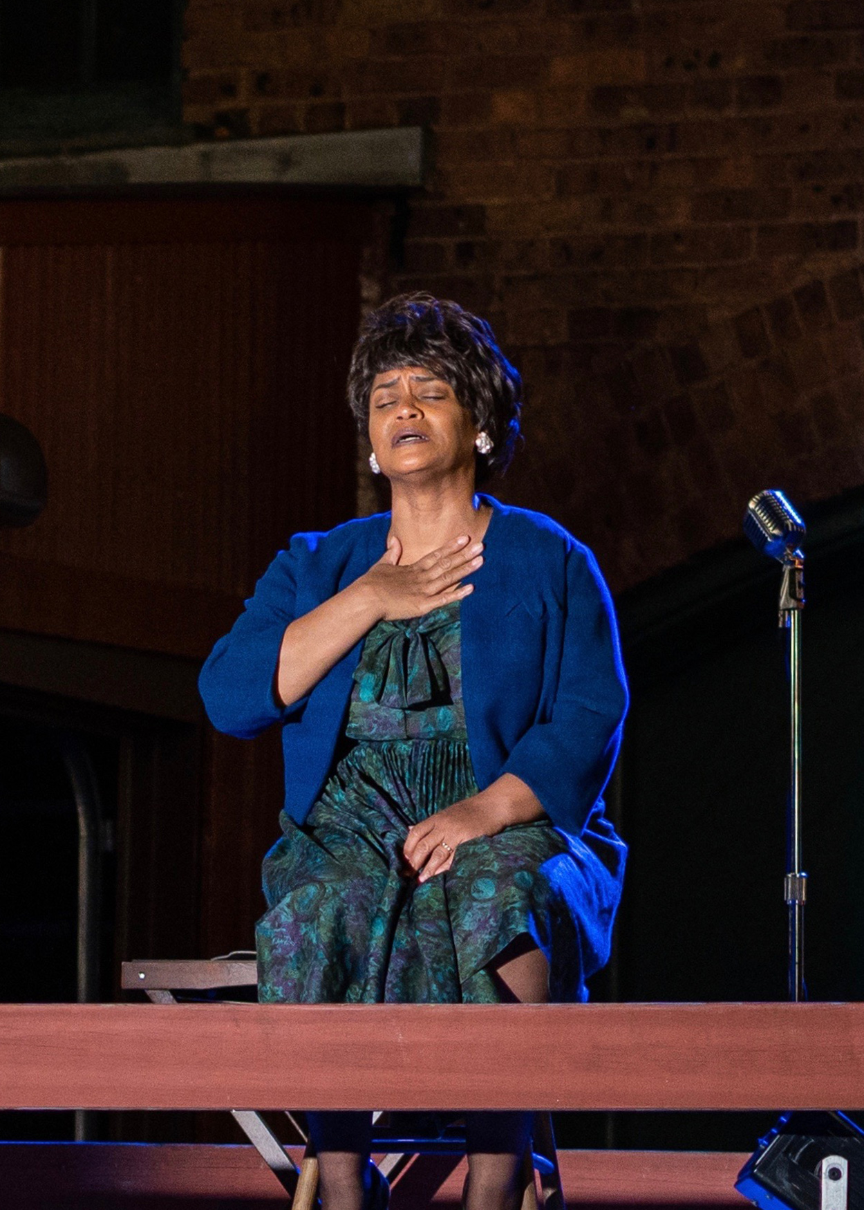 Production photo from Fannie Lou Hamer, Speak On It! (2020). Actress Rema Webb portrays civil rights activist Fannie Lou Hamer. Behind her is a sign that reads People Died So You Can Vote.