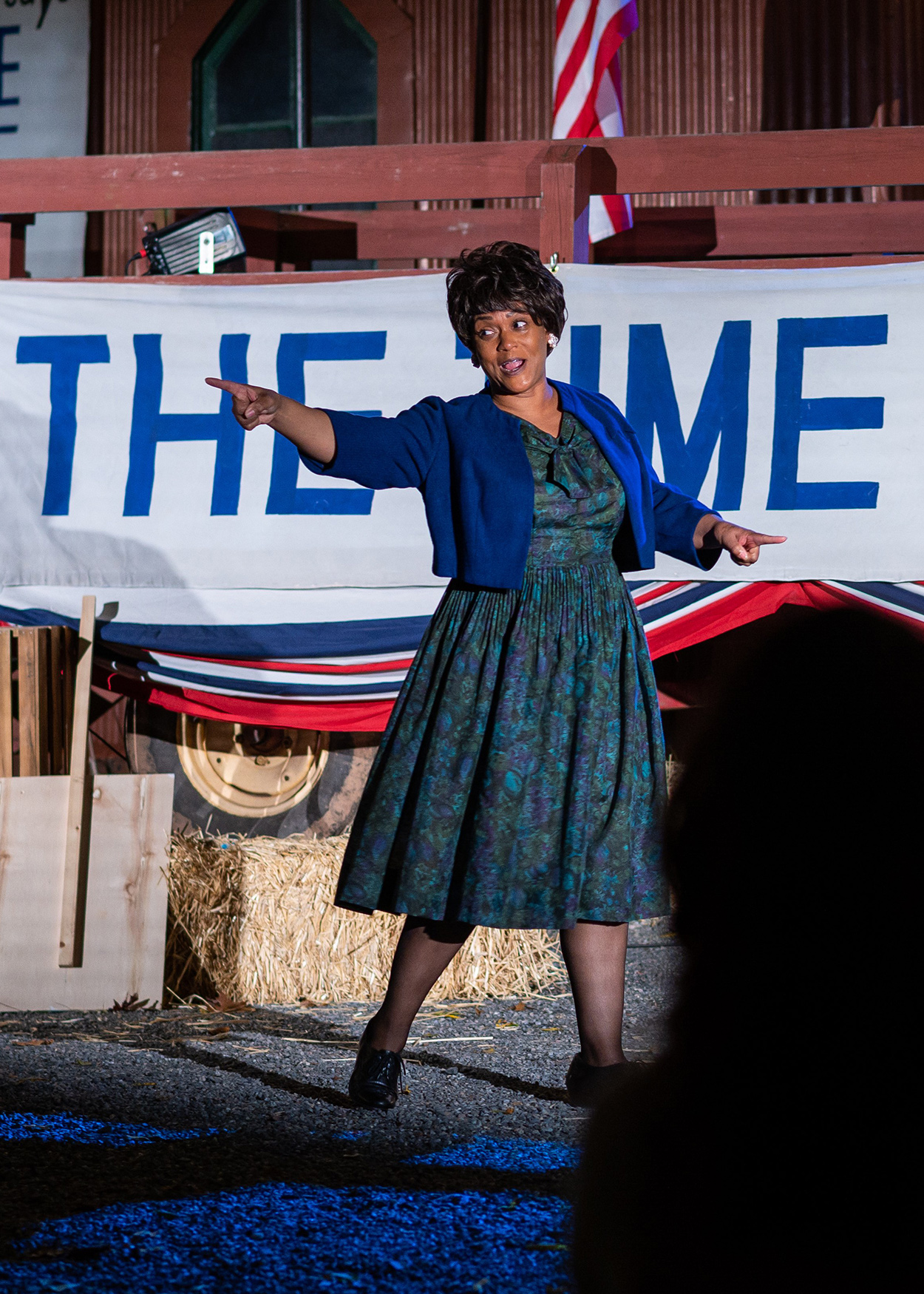 Production photo from Fannie Lou Hamer, Speak On It! (2020). Actress Rema Webb portrays civil rights activistFannie Lou Hamer. Behind her is a sign that reads The Time is Now.