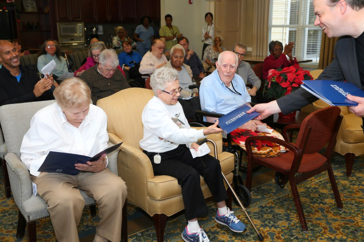 A large group of senior citizens in a common room.