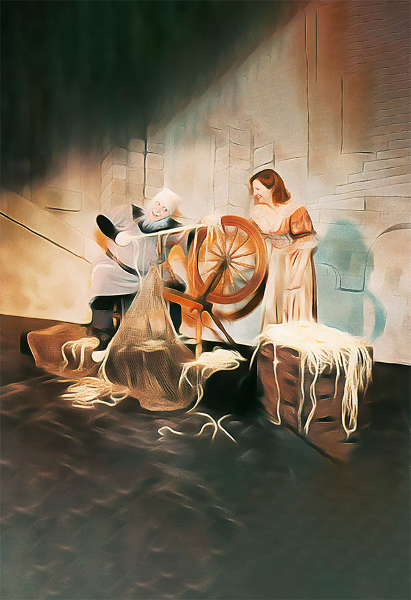 Rumplestiltskin and a woman with short hair in front of a spinning wheel and gold threads
