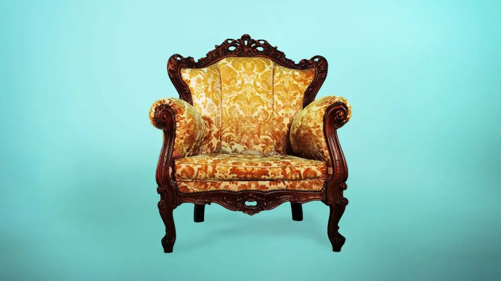 Victorian age chair with yellow fabric and leaf patterns and a blueish green background
