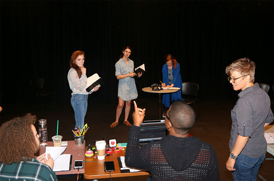 Six individual on a laptop, reading a script and directing a reading